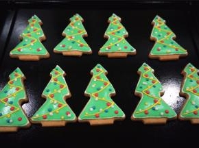 取少许白色的浓糖霜，加入少许蓝色素，调成蓝色的浓糖霜。分别用蓝色，红色，黄色，白色浓糖霜在圣诞树身上画上彩色点点，圣诞树糖霜饼干完成，放置通风处晾干即可。