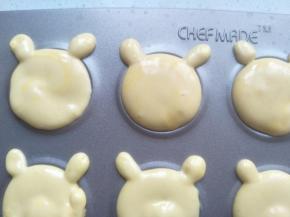 再拿一个裱花袋，剪小一点的口，挤上两个小圆形做耳朵。余留的面糊同样操作