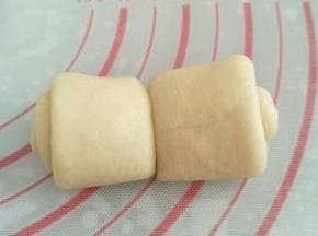 用刮板将面卷从中间对切开来