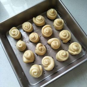 将面卷整齐的排放在烤盘中。盖上保鲜膜，放温暖处进行第二次发酵