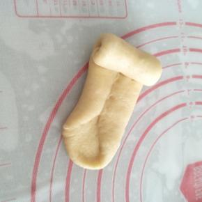 将面团的底部用手指压薄，再从上向下将面团卷起