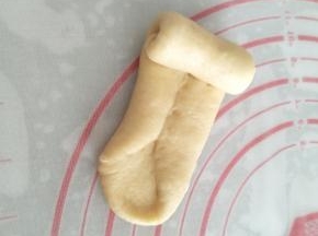 将面团的底部用手指压薄，再从上向下将面团卷起