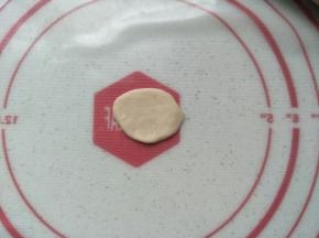 再次将红色面团排气滚圆，排入模具中。白色面团擀至如图状