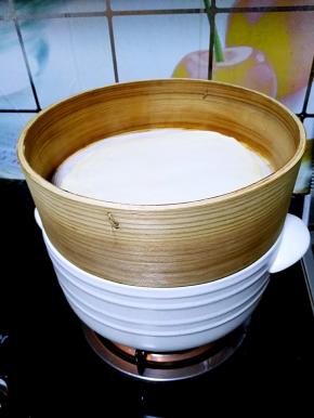 陶煲王的蒸锅中烧开水，之后把擀好的饺子皮上锅蒸。
