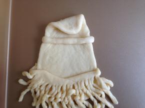 将水滴状上面尖的部分向里内折一下，另取一小面团搓成细长条放在上面，帽子形状初现