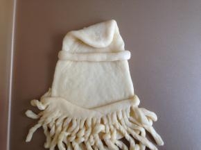 将水滴状上面尖的部分向里内折一下，另取一小面团搓成细长条放在上面，帽子形状初现