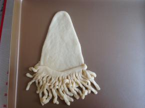 将胡须部分放在水滴面片的1/4处，并且将细长条扭一扭，随意地摆放即可