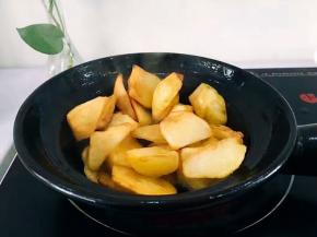 油热后，将沥干水分得土豆放入，小火