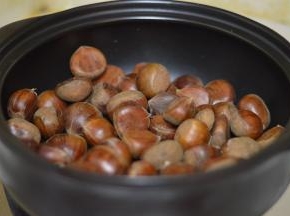 刚买回来的黑乐砂锅不需要清洗，用干抹布擦净灰尘，然后放入处理好的栗子。