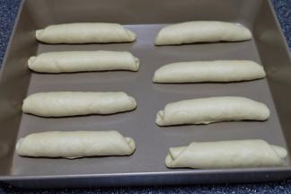 把卷好的面包卷依次摆在烤盘里，放置在烤箱里发酵至两倍大，大约30分钟就可以了；