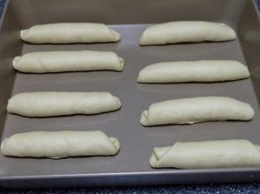 把卷好的面包卷依次摆在烤盘里，放置在烤箱里发酵至两倍大，大约30分钟就可以了；