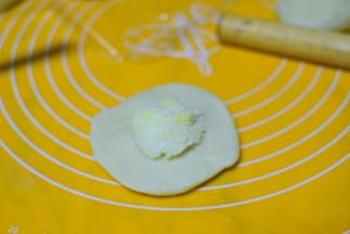 把每个小面团擀成小饼，把椰蓉馅儿放在中间。