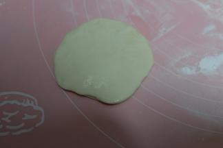 取一个抹了油的面皮，再将一个没有抹油的面皮压在上面；