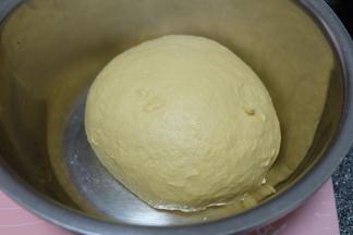 揉成一个光滑柔软富有弹性的面团，盖上保鲜膜，静置发酵至两倍大。（我是上午揉的面，因为中午要出门，需要延长发酵时间，所以把面团转到小盆里，放在冰箱里冷藏发酵，如果时间充足，可以在面包机里不要动，直接发酵到两倍大再取出来）