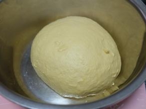 揉成一个光滑柔软富有弹性的面团，盖上保鲜膜，静置发酵至两倍大。（我是上午揉的面，因为中午要出门，需要延长发酵时间，所以把面团转到小盆里，放在冰箱里冷藏发酵，如果时间充足，可以在面包机里不要动，直接发酵到两倍大再取出来）