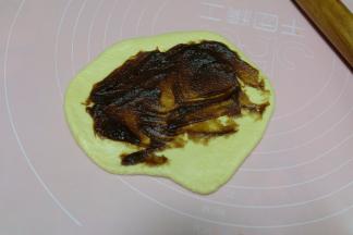 静置好的面团会有些长大，用擀面杖擀开排气，抹上一层枣泥馅；（可以把枣泥馅换成其它的馅料，也可以不放馅直接卷）