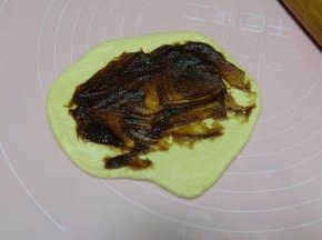 静置好的面团会有些长大，用擀面杖擀开排气，抹上一层枣泥馅；（可以把枣泥馅换成其它的馅料，也可以不放馅直接卷）