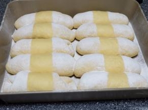 用两张长条形状的白纸盖住面包的中间，将面粉过筛到面包上，再把白纸去掉，就可以是图中的样子了；