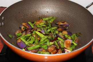 沥干油的茄子、四季豆倒入翻炒；