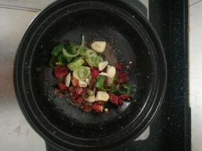 锅底留油，放入大蒜，葱圈，八角，干辣椒炒香。