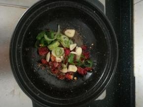 锅底留油，放入大蒜，葱圈，八角，干辣椒炒香。