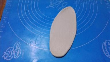 将面团擀成牛舌状，排出多余的气体