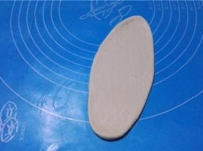 将面团擀成牛舌状，排出多余的气体