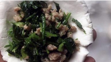 取一个糯米圆子压扁，包入荠菜馅，然后收口搓圆