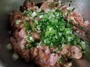 猪肉馅加酱油腌渍一会，然后把葱末倒入。