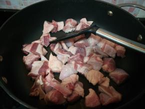 烧热锅，倒少许油，加入牛腩翻炒。