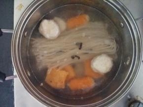 先在锅里倒入400-500毫升的水煮沸，放入米粉和脱水木耳，各种丸子，煮到米粉能夹断，再放入一把青菜，再把米粉和料头捞起