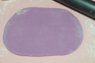 再把紫色面团取过来，一样擀成一个大的饼状；