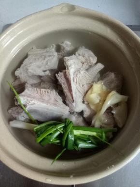 用砂锅倒入适量清水，放入焯好水的排骨，放入料酒1茶匙，葱，姜片