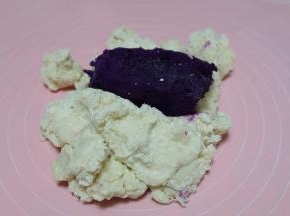 等面粉不烫手以后转移到揉面垫上，放上紫薯，紫薯是我之前蒸熟后预留的；