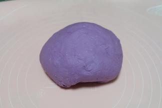 揉成一个光滑柔软的面团；烫面的面团揉好以后特别的软，手感很好；放在垫子上，扣个小盆静置10分钟左右，让面团休息一下。颜色在厨房的灯光下有些偏色了，实际是紫色的；