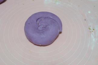 卷好的面是成长条的圆形的，再盘起来，把收扣放在下面，用手掌按扁；