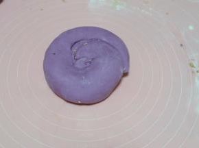 卷好的面是成长条的圆形的，再盘起来，把收扣放在下面，用手掌按扁；