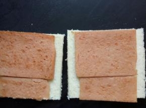 把煎好的午餐肉放在面包片上，其中有一片分一半