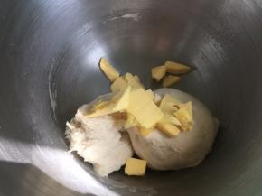 搅拌到面团到扩展阶段（即成团不粘手，可以拉出很厚很破裂的厚膜），然后倒入软化的黄油，继续揉面