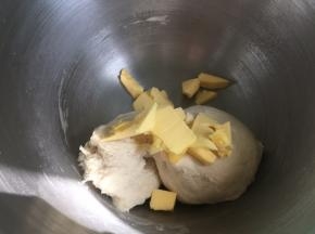 搅拌到面团到扩展阶段（即成团不粘手，可以拉出很厚很破裂的厚膜），然后倒入软化的黄油，继续揉面