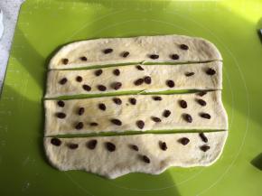 用硅胶刷均匀刷上做好的炼乳酱，撒上葡萄干（提前泡过温水的葡萄干，再用厨房用纸吸干水分），把面皮切成4份