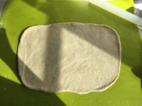 取出发酵好的面团，排气擀成长方形，盖上保鲜膜松弛10分钟