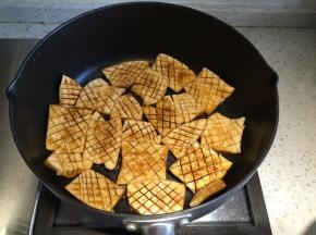 平底锅内加入少许食用油，开火，把杏鲍菇片夹入，中小火煎