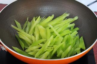 炒过腊肠的油锅，莴笋倒入锅中，爆炒片刻；