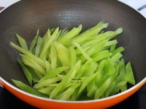 炒过腊肠的油锅，莴笋倒入锅中，爆炒片刻；