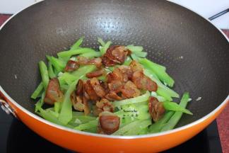 加入腊肠一起翻炒；