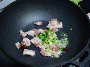 锅中油七成热，加入八角加肉炒香，再加入葱姜蒜各5克，炒至肉段生。