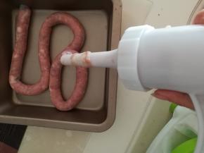 开始转灌肠器把肉灌进肠衣里，灌的时候不要太满，7分满就够了。