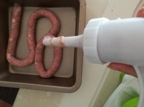 开始转灌肠器把肉灌进肠衣里，灌的时候不要太满，7分满就够了。