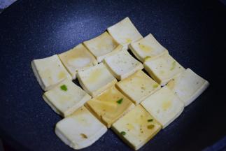 锅中油热，将千页豆腐放入锅中煎制